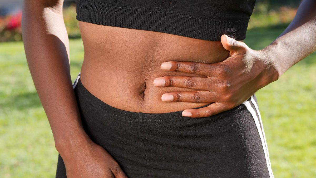 Person holding abdomen in pain — appendicitis