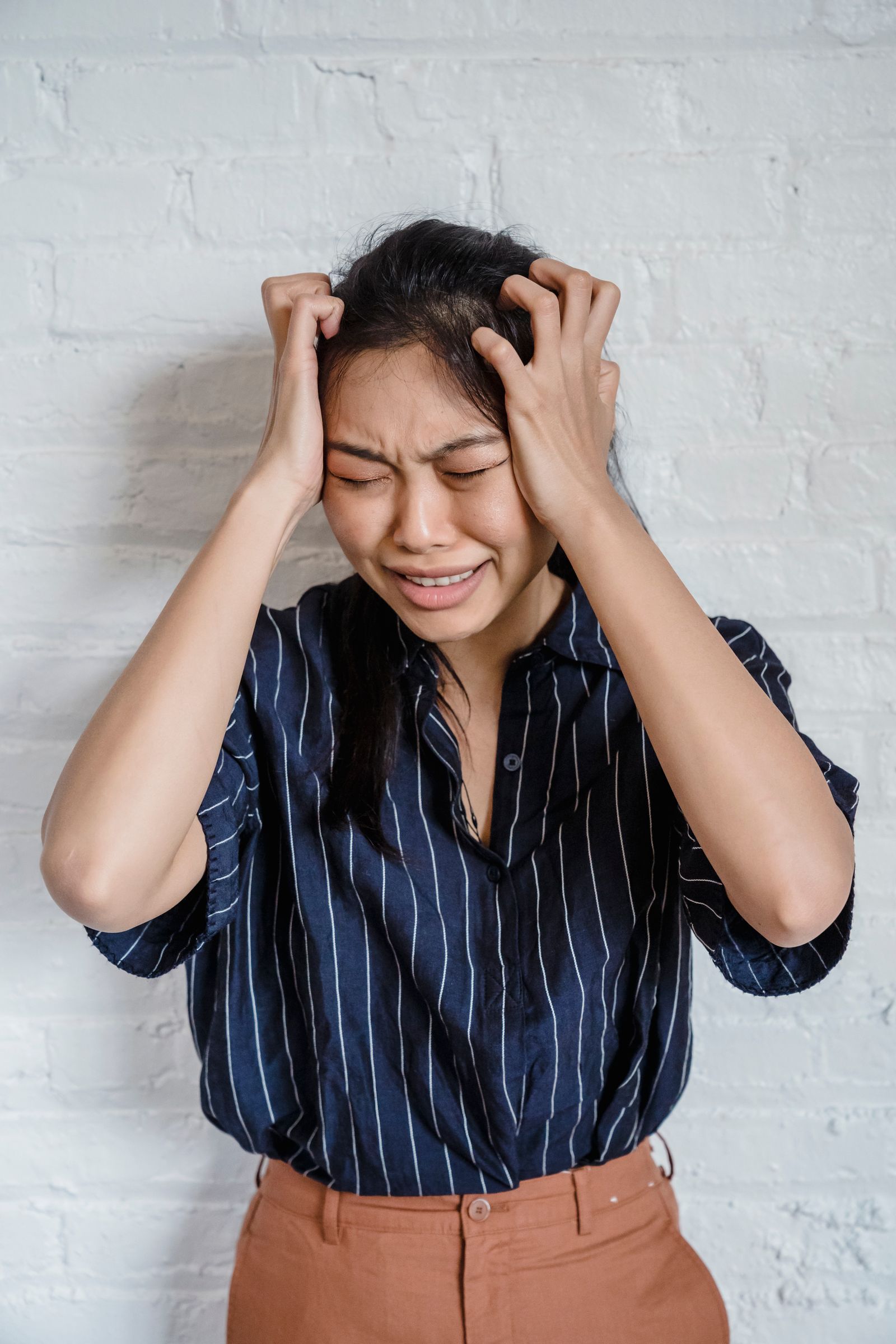 Person holding their head due to dizziness and vertigo