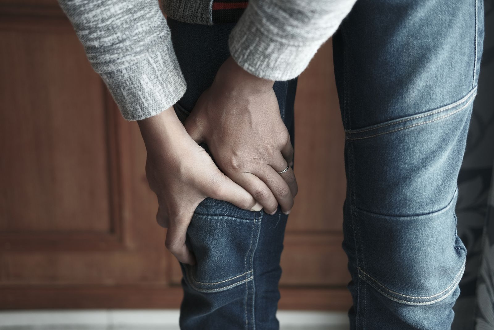 Person holding painful, swollen knee joint