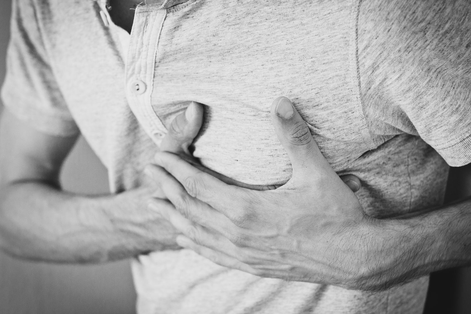 Person holding chest experiencing heartburn discomfort