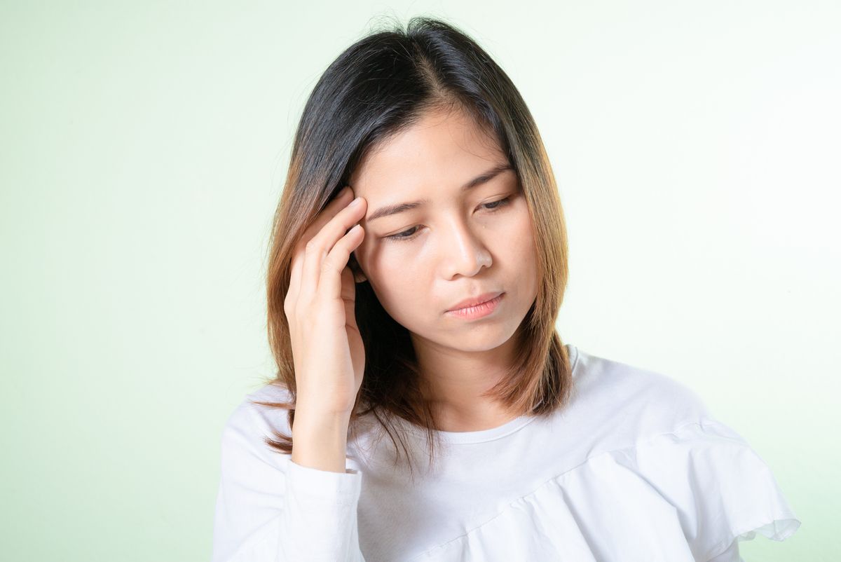 Person holding head in pain — migraine headache