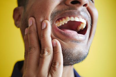 Person with toothache holding jaw