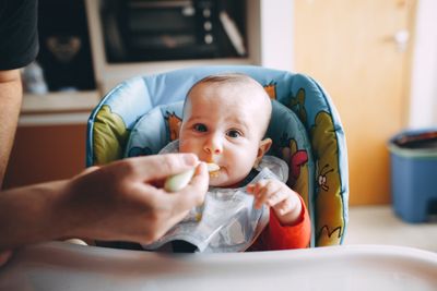 Baby being spoon-fed solid food
