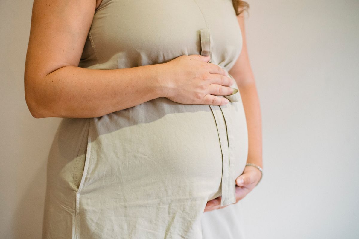 Pregnant woman holding her belly — third month pregnancy