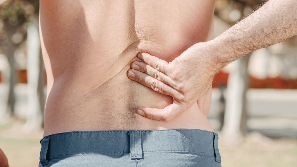 Person holding lower back in pain — sciatica